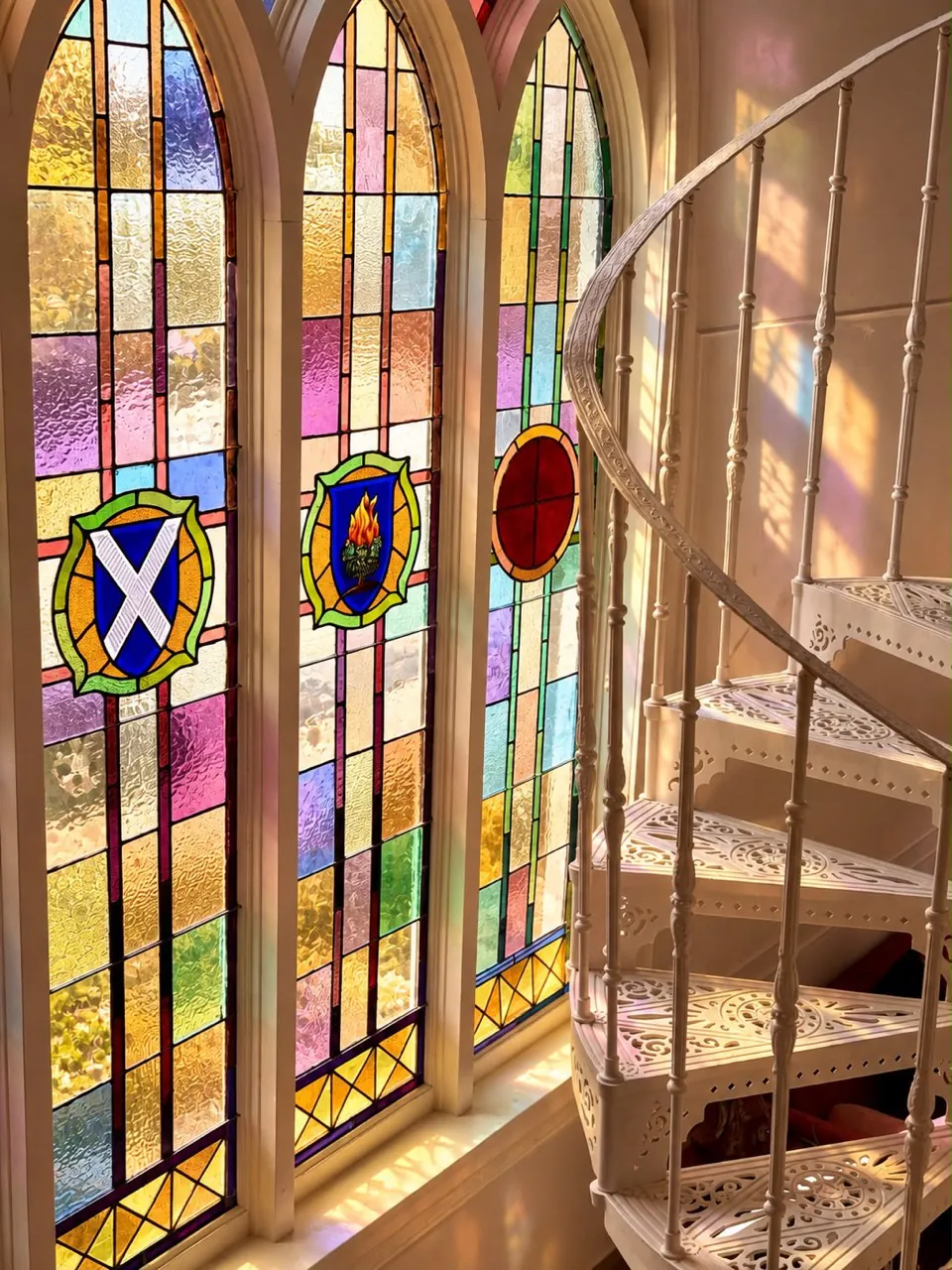 Les vitraux baignés de soleil près de l’escalier blanc du Château
